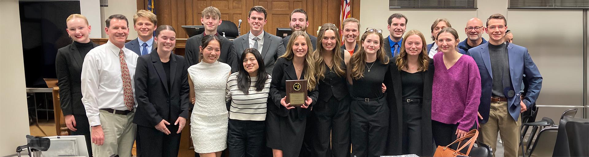 Cedarville University&#39;s mock trial team smiling and holding award plaque.